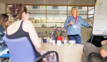 a woman explaining something to a group of people